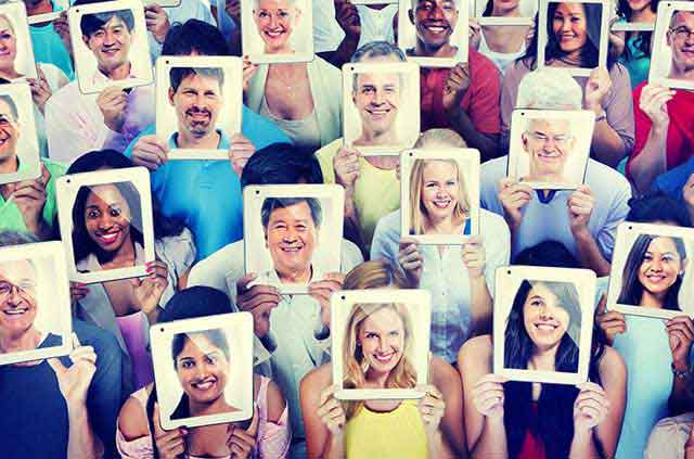 Crowd of people using tablets with their visages.